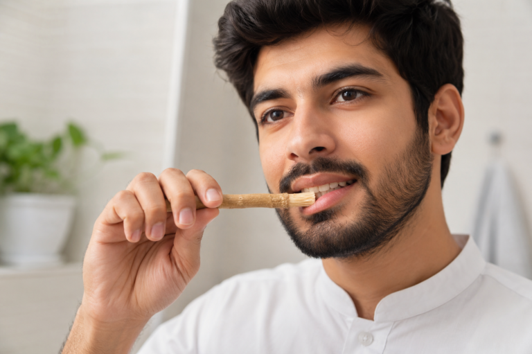Person using a fresh miswak stick correctly for oral care