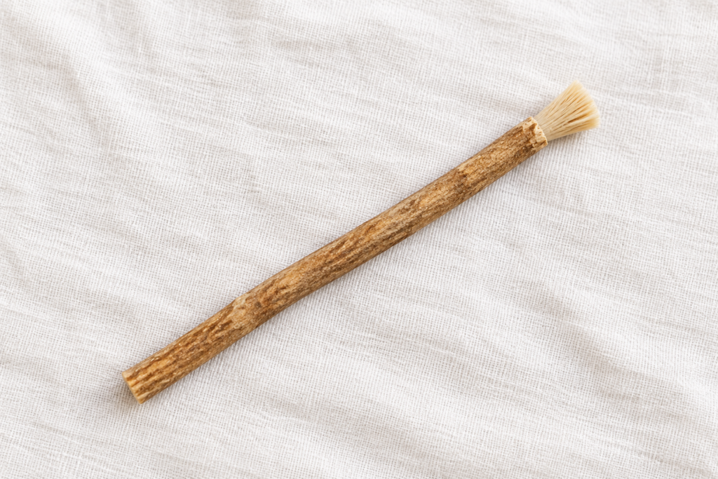 Untreated miswak stick laid across white woven cotton cloth