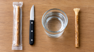 Miswak stick, knife and water laid out for preparing a new miswak